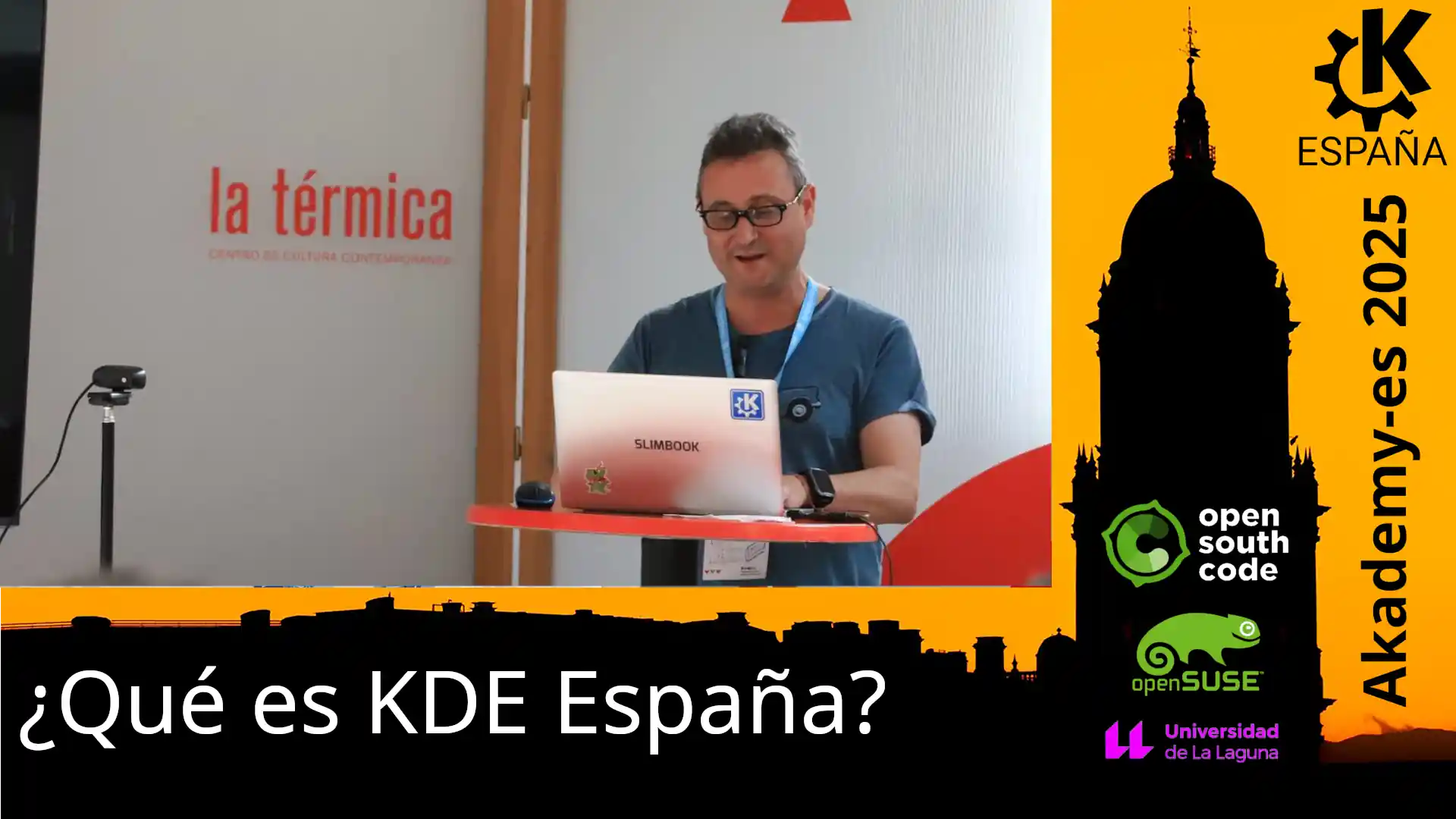 Baltasar dando esta charla con un Slimbook y de fondo se ve el cartel de la AkademyES 2025 con los logos de OSC, openSUSE y La Universidad de la Laguna